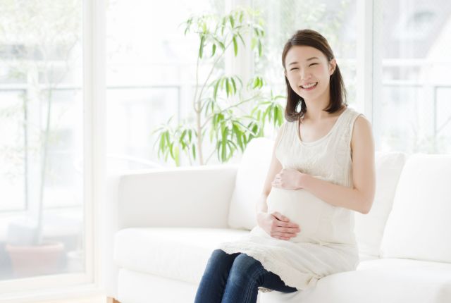 お腹に手を当てる妊婦さん