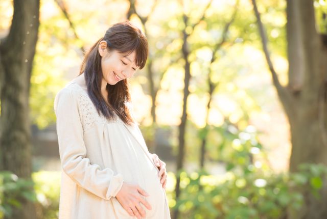 お腹に手を当てる妊婦さん