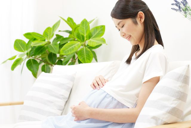 お腹に手を当てる妊婦さん