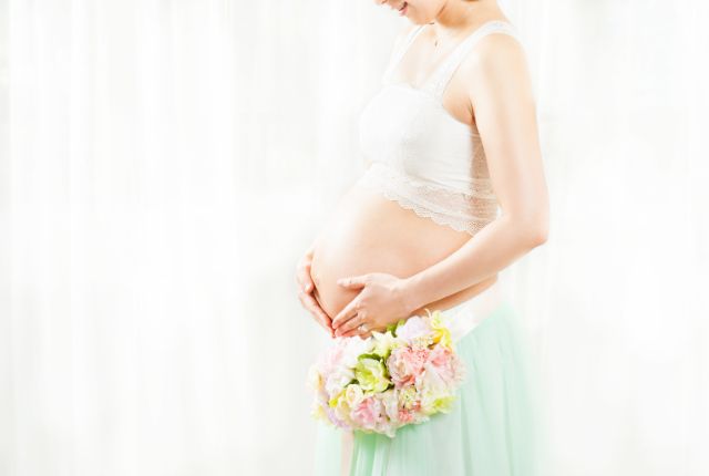 お腹に手を当てる妊婦さん